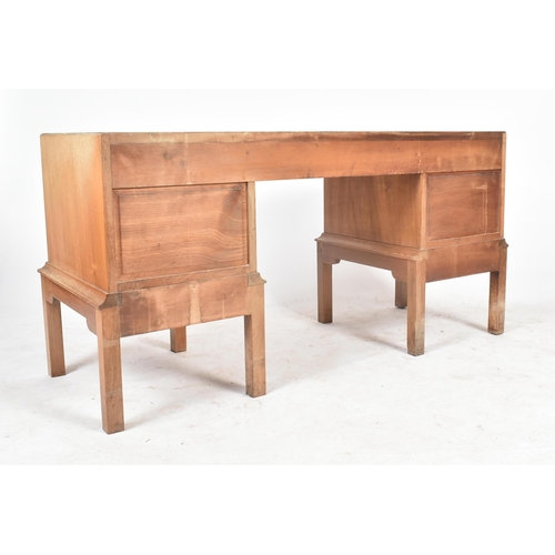 25 - Gordon Russell - A vintage 20th century 1940s solid walnut writing table desk. The desk having a cen... 