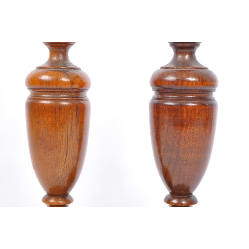 247 - A pair of early 20th century turned wood and silver candlesticks. The candlesticks having ornate sil... 