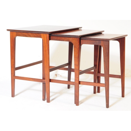 622 - A vintage 20th century teak wood nest of tables. Of rectangular form with upright square supports un... 