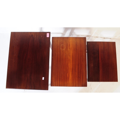 622 - A vintage 20th century teak wood nest of tables. Of rectangular form with upright square supports un... 