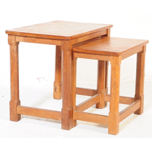 650 - A vintage Robert 'Mouseman' Thompson oak nest of two tables. Having rectangular tops over four octag... 