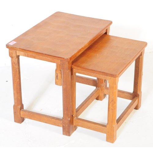 650 - A vintage Robert 'Mouseman' Thompson oak nest of two tables. Having rectangular tops over four octag... 