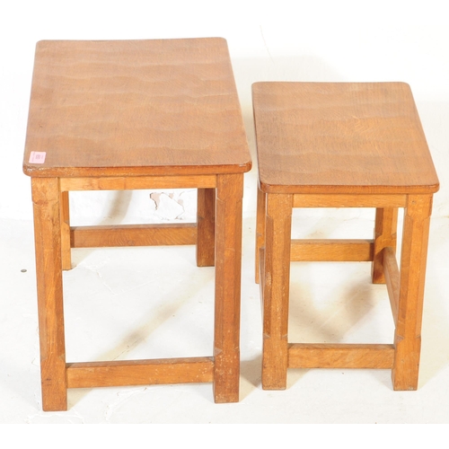 650 - A vintage Robert 'Mouseman' Thompson oak nest of two tables. Having rectangular tops over four octag... 