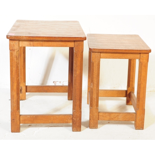 650 - A vintage Robert 'Mouseman' Thompson oak nest of two tables. Having rectangular tops over four octag... 