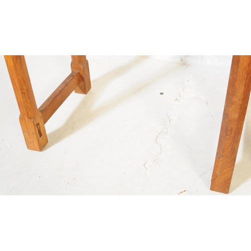 650 - A vintage Robert 'Mouseman' Thompson oak nest of two tables. Having rectangular tops over four octag... 