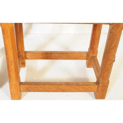 650 - A vintage Robert 'Mouseman' Thompson oak nest of two tables. Having rectangular tops over four octag... 