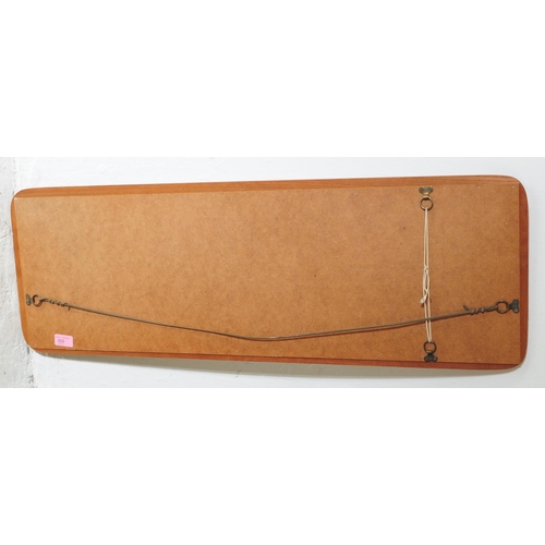 655 - A mid 20th century Danish inspired hanging wall mirror. Having a rectangular mirrored panel mounted ... 