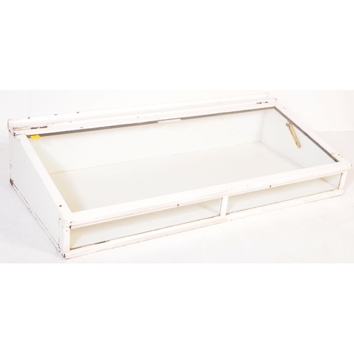 694 - A large 20th century oak glazed haberdashery shop display case having lift up sloped top, all painte... 