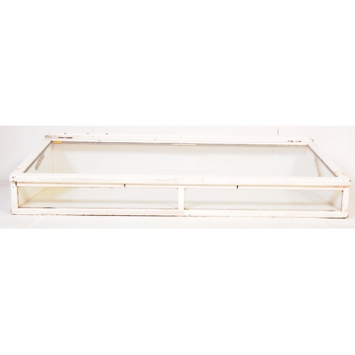 694 - A large 20th century oak glazed haberdashery shop display case having lift up sloped top, all painte... 