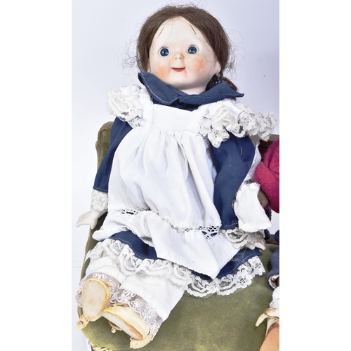 494 - A collection of x3 vintage porcelain / bisque headed dolls with cloth bodies and fixed eyes seated o... 