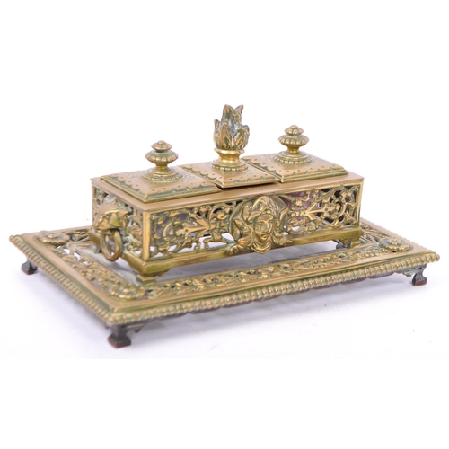 201 - A late Victorian brass inkstand fitted with two round white / pink moulded glass inkwells and incorp... 