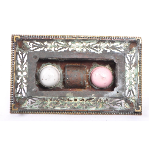 201 - A late Victorian brass inkstand fitted with two round white / pink moulded glass inkwells and incorp... 