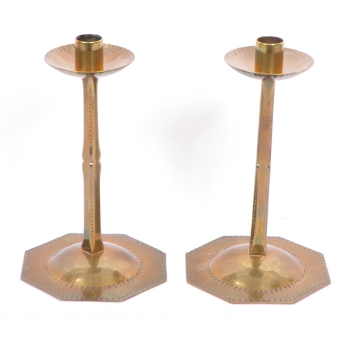 213 - A pair of mid 20th century brass candle stick holders, having a shaped and perforated central column... 