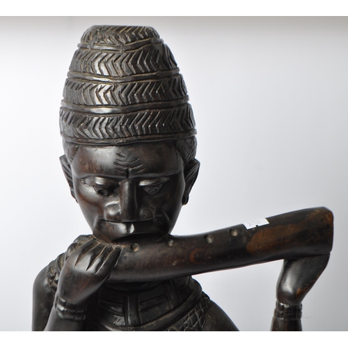 215 - An early to mid 20th Century African - Benin carved wooden figurine depicting a Horn Player. This fi... 