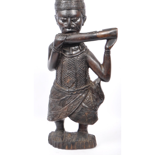 215 - An early to mid 20th Century African - Benin carved wooden figurine depicting a Horn Player. This fi... 