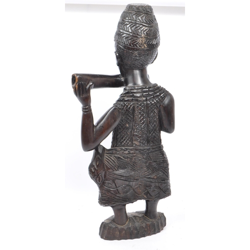 215 - An early to mid 20th Century African - Benin carved wooden figurine depicting a Horn Player. This fi... 