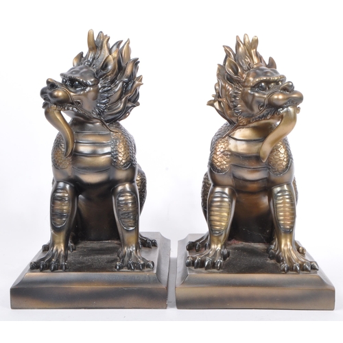 216 - A pair of vintage 20th century resin Chinese inspired Foo dogs bookends. Each having a tailed foo do... 