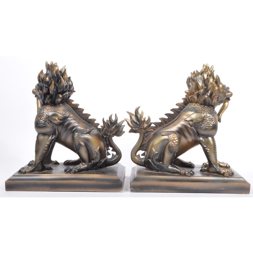 216 - A pair of vintage 20th century resin Chinese inspired Foo dogs bookends. Each having a tailed foo do... 