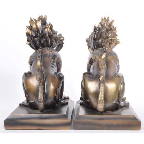 216 - A pair of vintage 20th century resin Chinese inspired Foo dogs bookends. Each having a tailed foo do... 