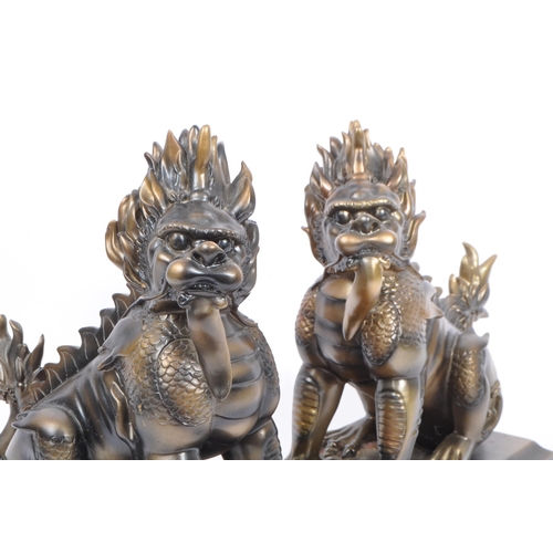 216 - A pair of vintage 20th century resin Chinese inspired Foo dogs bookends. Each having a tailed foo do... 