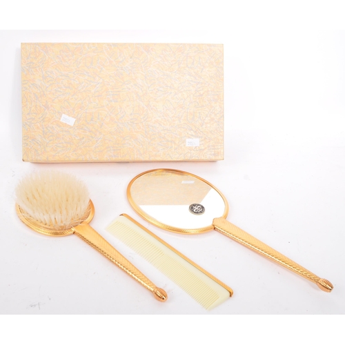 225 - An Art Deco 1940s three piece vanity set. Comprising of clothes brush, comb and hand mirror.  Of ova... 