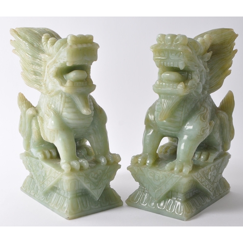 24 - A pair of vintage 20th century jade style green stone Fu foo / temple guard dogs. In a seated postin... 