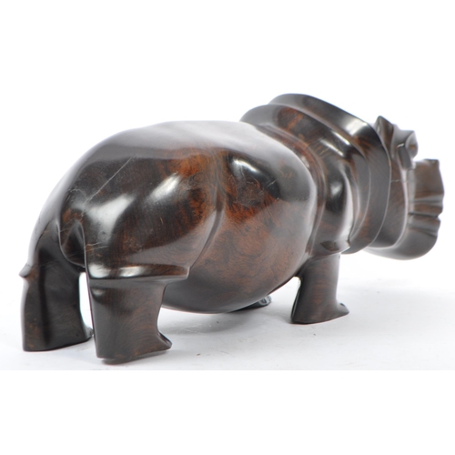 266 - A 20th century African hardwood figure in the form of a hippopotamus having hand carved details inse... 