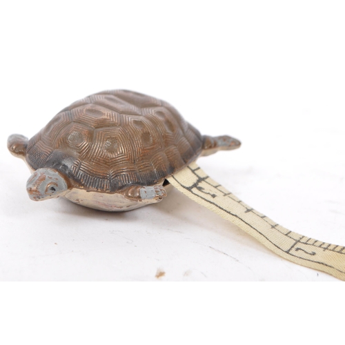 272 - An early 20th century cold painted metal tape measure in the form of a turtle with patterning to bac... 