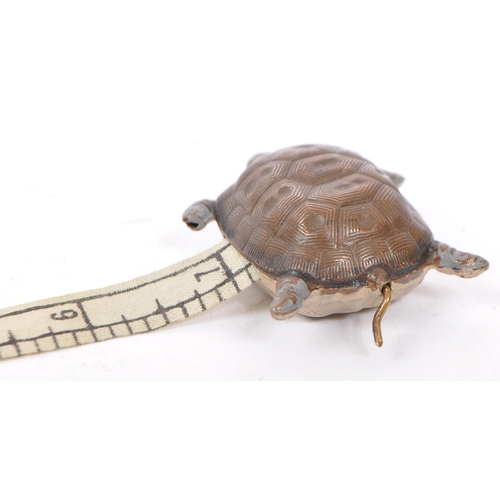 272 - An early 20th century cold painted metal tape measure in the form of a turtle with patterning to bac... 