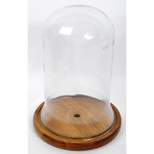 303 - Two vintage glass display domes dating from the early 20th Century. One smaller and raised on a circ... 