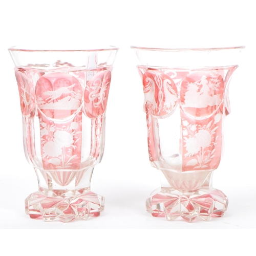 32 - A pair of early 20th Century part cranberry glass drinking wine goblets glasses having etched huntin... 