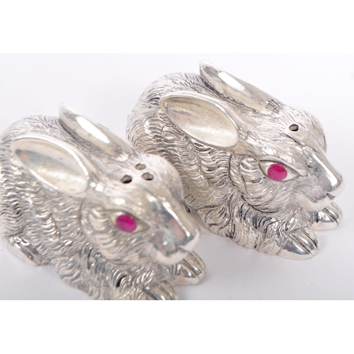 337 - A pair of silver plated condiments in the from of crouching rabbits having engraved features and fac... 