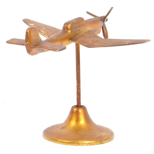 348 - A mid 20th century brass trench art type airplane having articulated propeller and being raised upon... 