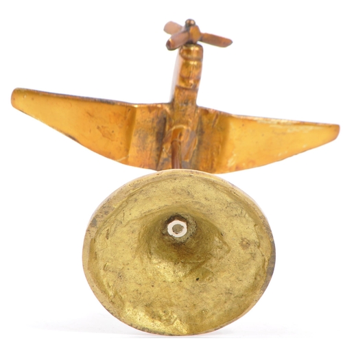 348 - A mid 20th century brass trench art type airplane having articulated propeller and being raised upon... 