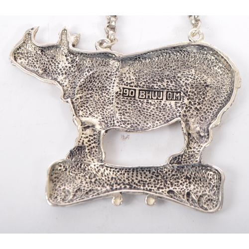 363 - A silver plated whiskey decanter label having a rhinoceros to top over a banner reading Whiskey on c... 