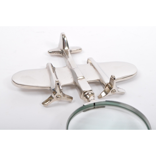 368 - A chrome hand held magnifying glass having handle in the form of a fighter jet. Measures 24cm length... 