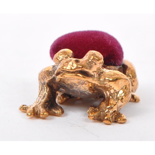 372 - A copper metal pin cushion in the form of a frog with red velvet cushion to back. Measures 22mm leng... 