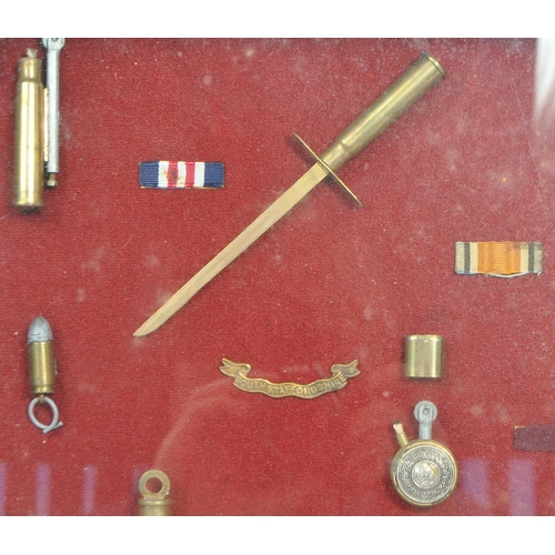 386 - A mid century collection of cased brass trench art examples. To include lighters, letter opener, lea... 