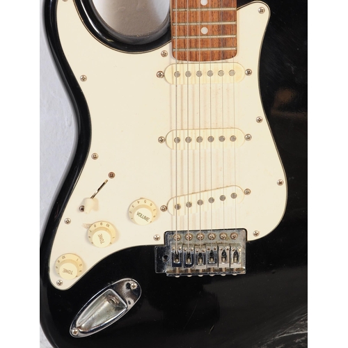 409 - A vintage electric guitar by Encore. Stratocaster style guitar / musical instrument having a black b... 