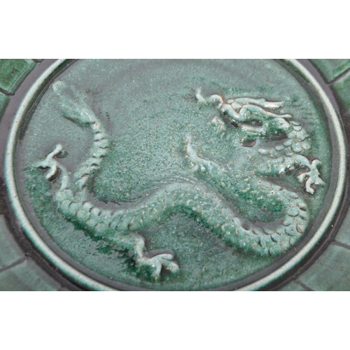 67 - A 19th century Chinese stoneware plate having green glazer with relief Chinese dragon to centre. Bas... 