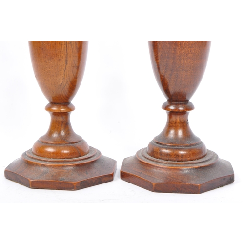 282 - A pair of early 20th century turned wood and silver candlesticks. The candlesticks having ornate sil... 