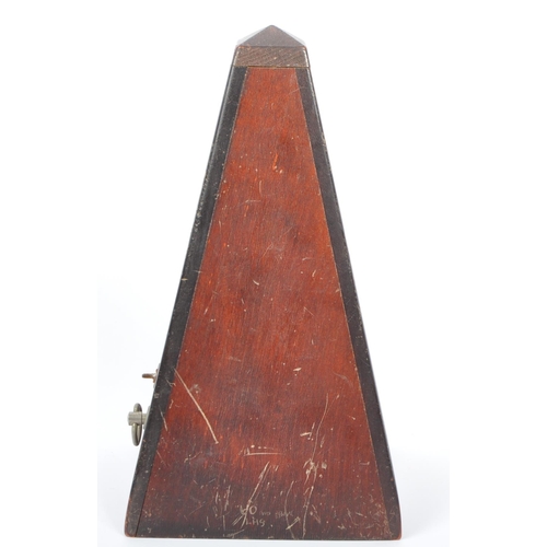 292 - A vintage 20th century wooden construction musical tempo metronome. In a painted pyramid wooden hous... 