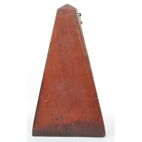 292 - A vintage 20th century wooden construction musical tempo metronome. In a painted pyramid wooden hous... 