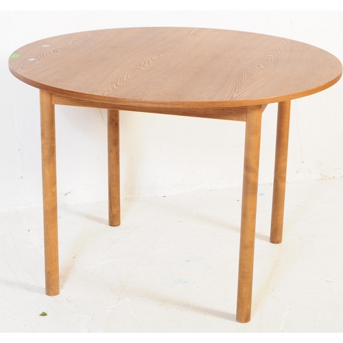 603 - A retro mid 20th century teak dining table with chairs. The table of circular form with round suppor... 