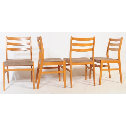 603 - A retro mid 20th century teak dining table with chairs. The table of circular form with round suppor... 