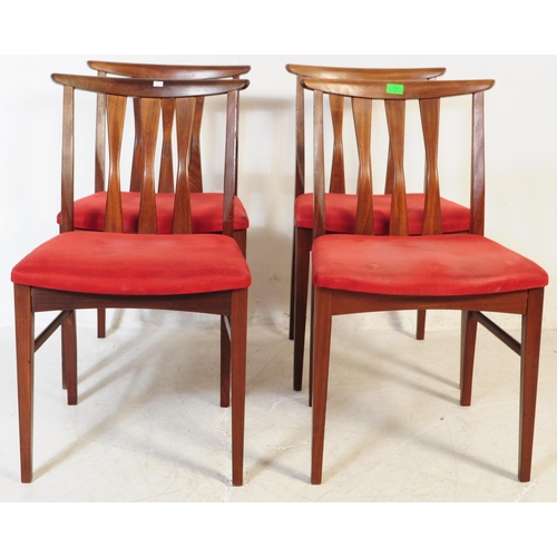 614 - A set of four mid 20th century teak Danish inspired dining chairs. Each having shaped top rails over... 