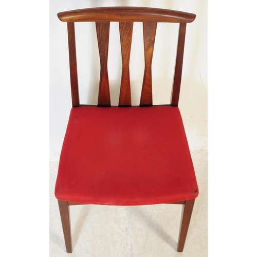 614 - A set of four mid 20th century teak Danish inspired dining chairs. Each having shaped top rails over... 