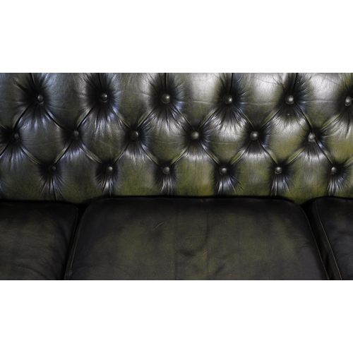 669 - A late 20th century button backed three seater sofa settee couch with arm chair in a chesterfield st... 