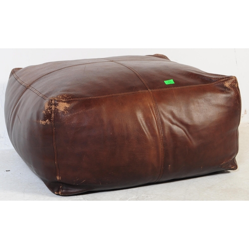 674 - A large contemporary brown leather stitched pouffe - lazy cushion. Of large square form with brown l... 