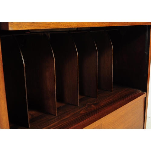 689 - A mid century walnut twin door filing cabinet. The desk raised on a plinth base with pedestal having... 